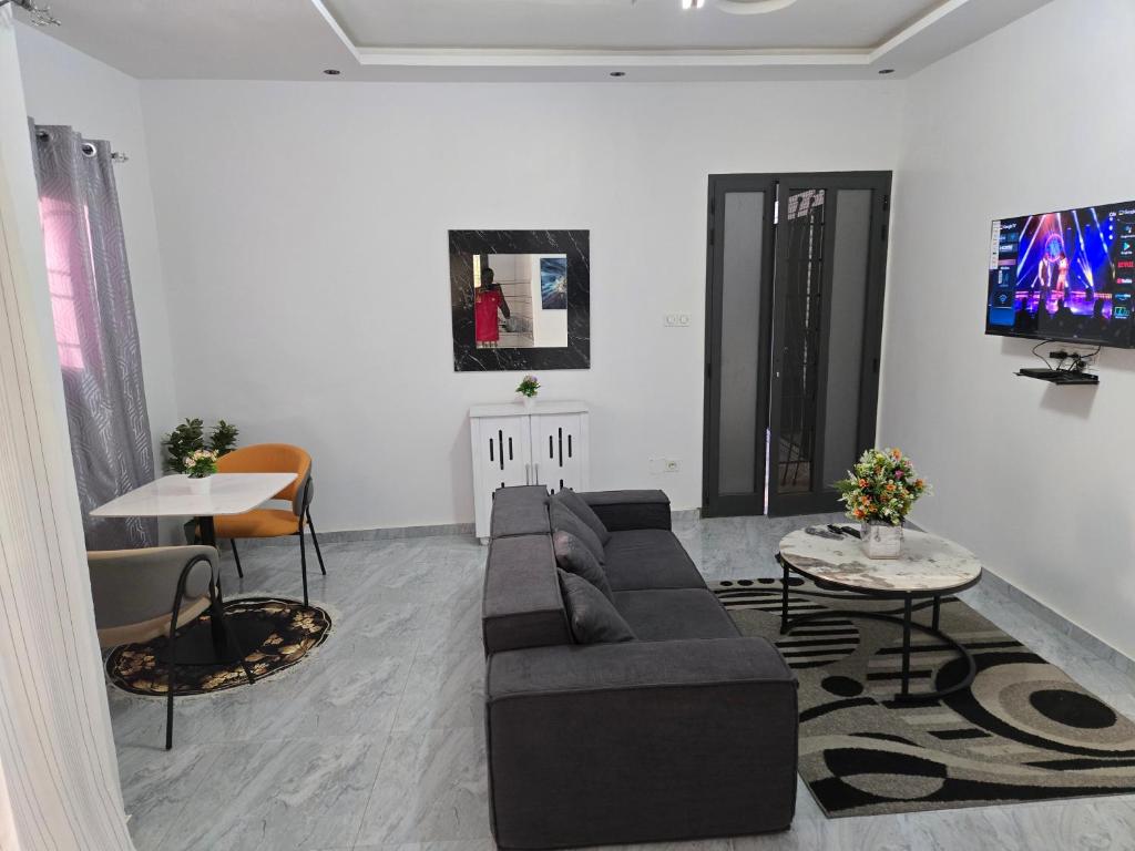a living room with a couch and a tv at SUITE RESIDENCE TERANGAWALo in Richard Toll