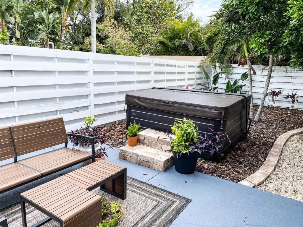 eine Terrasse mit zwei Bänken und einem Whirlpool in der Unterkunft Ringling Cottage in Bailey Hall