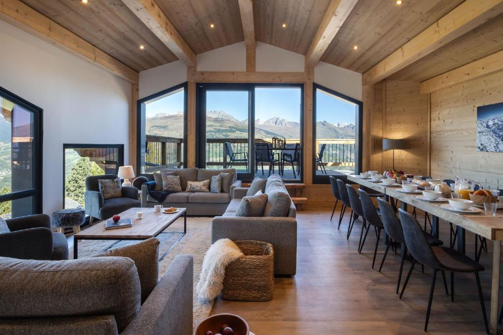 ein Esszimmer mit Sofas und eine Bar mit Aussicht in der Unterkunft Chalet Mathilde Les Coches Saturday Changeover in Les Coches