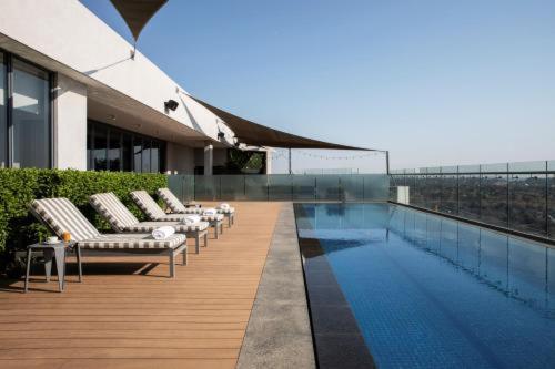 a row of chaise lounges on a building with a pool at 1128 Executive Studio, The Capital Triology in Pretoria