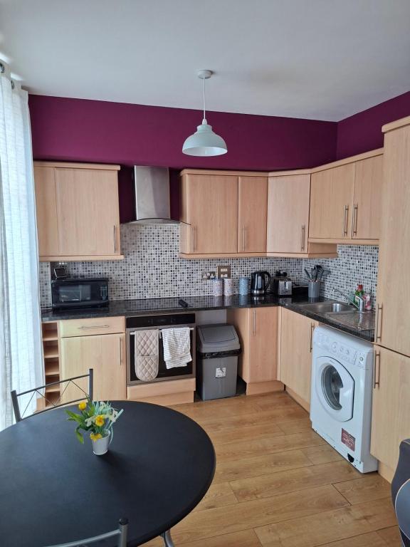 eine Küche mit einem Tisch und eine Küche mit lila Wänden in der Unterkunft Two bedroom flat in Darlington in Darlington