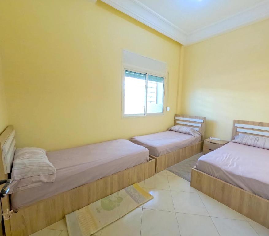 a bedroom with two beds and a window at Hassan Apartment - Ideal for Riders, Free Garage Parking Included in Sale