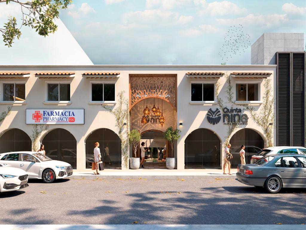 un bâtiment avec des voitures garées devant dans l'établissement Quinta Nina Playa del Carmen - Solo Adultos, à Playa del Carmen