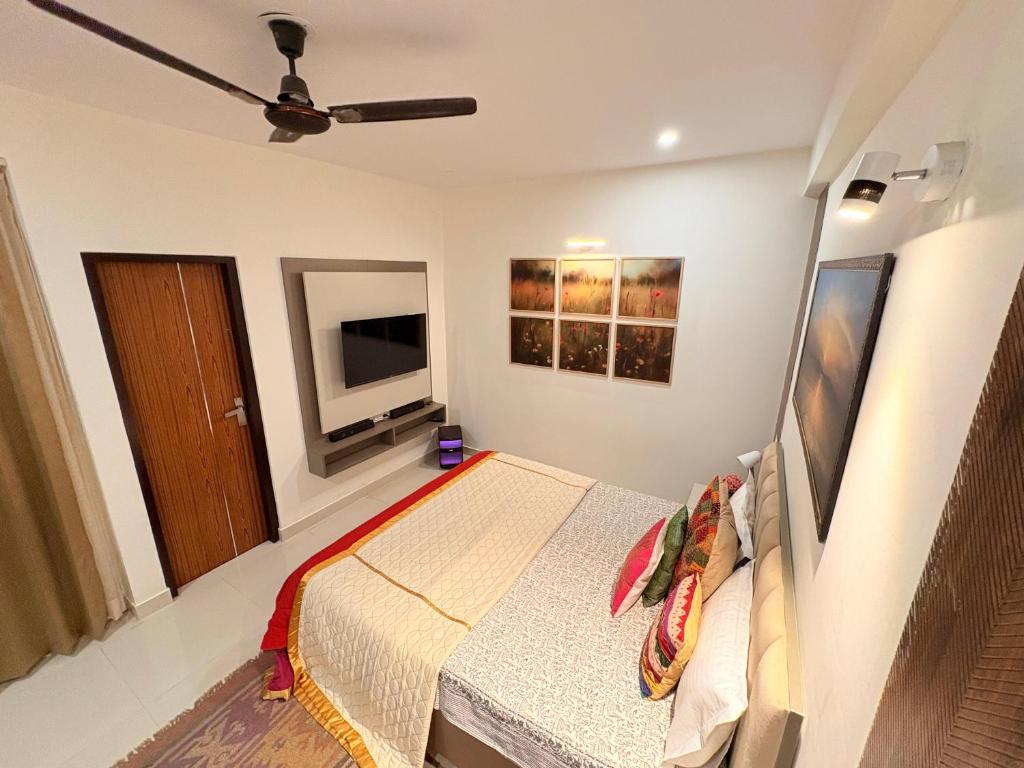 a bedroom with a bed and a flat screen tv at Couple Canvas- Luxurious 1-BHK Peaceful Apartment in Siroli