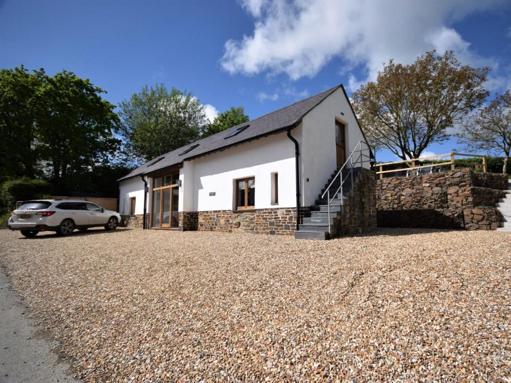 a white house with a car parked in front of it at 2 Bed in Kings Nympton 87985 in Kings Nympton