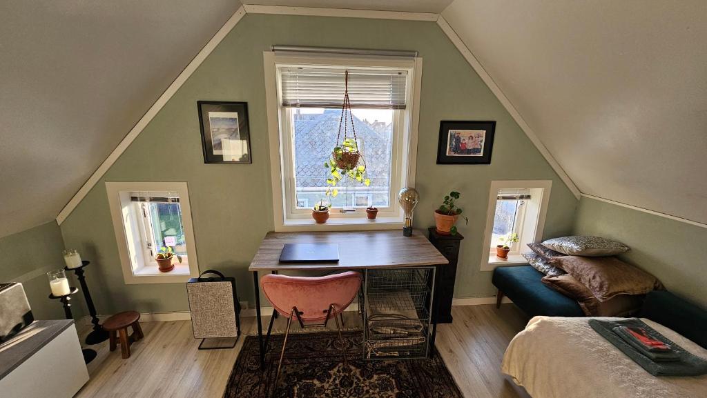 una stanza con un tavolo, un letto e una finestra di Large room, unique loftspartment, balcony, free parking ad Ålesund