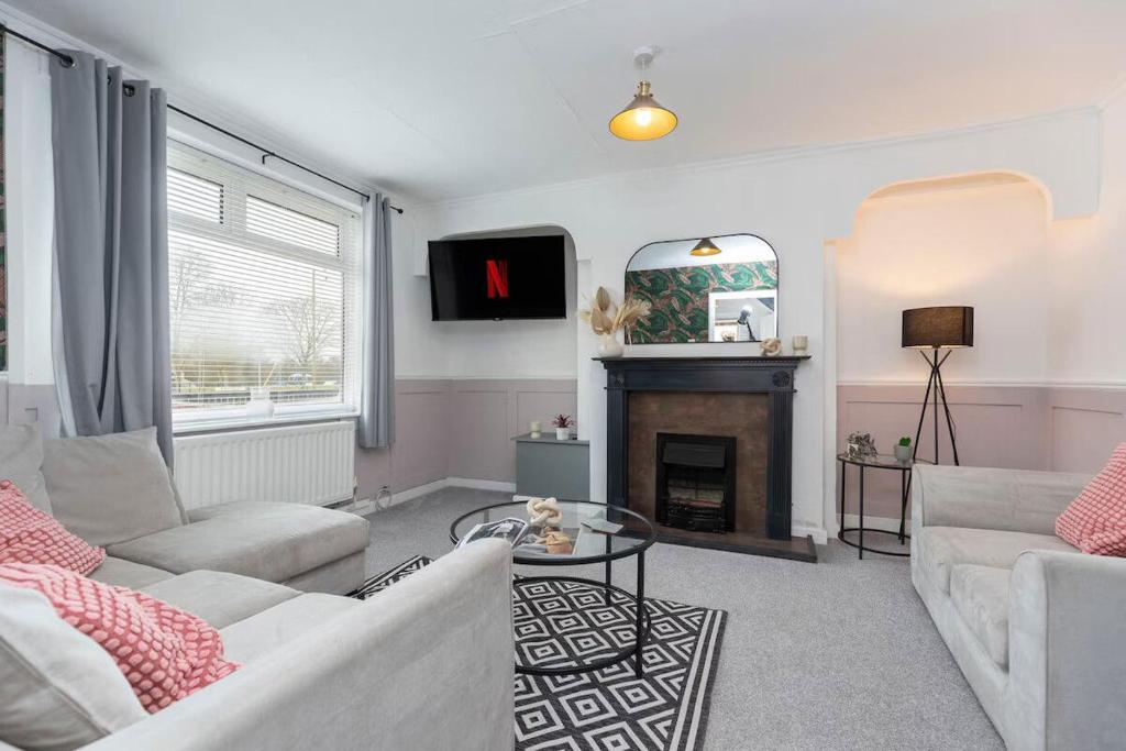 a living room with two couches and a fireplace at Park House in Durham