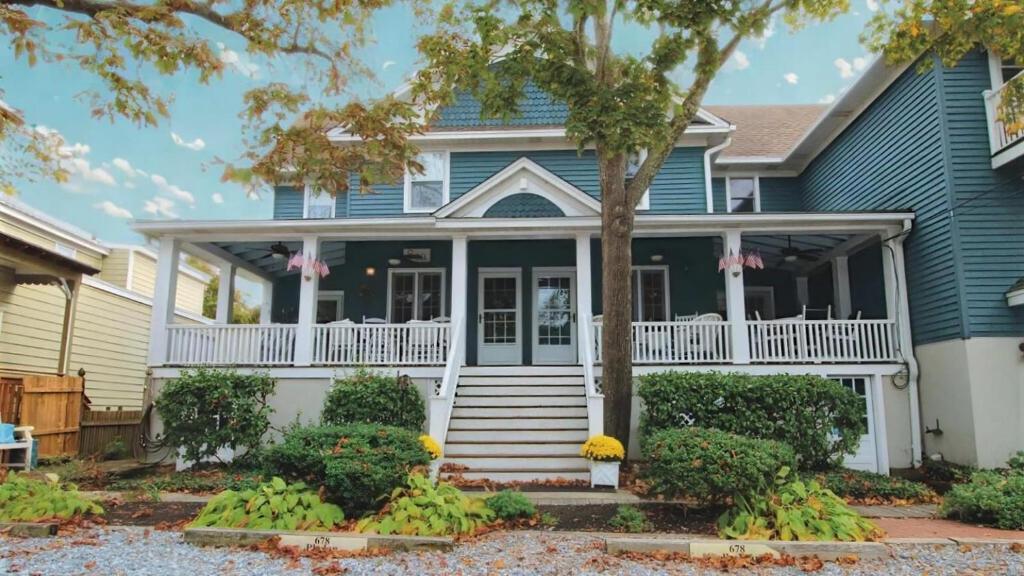une maison bleue avec un porche blanc et des balustrades blanches dans l'établissement Heritage House 2, à Cape May