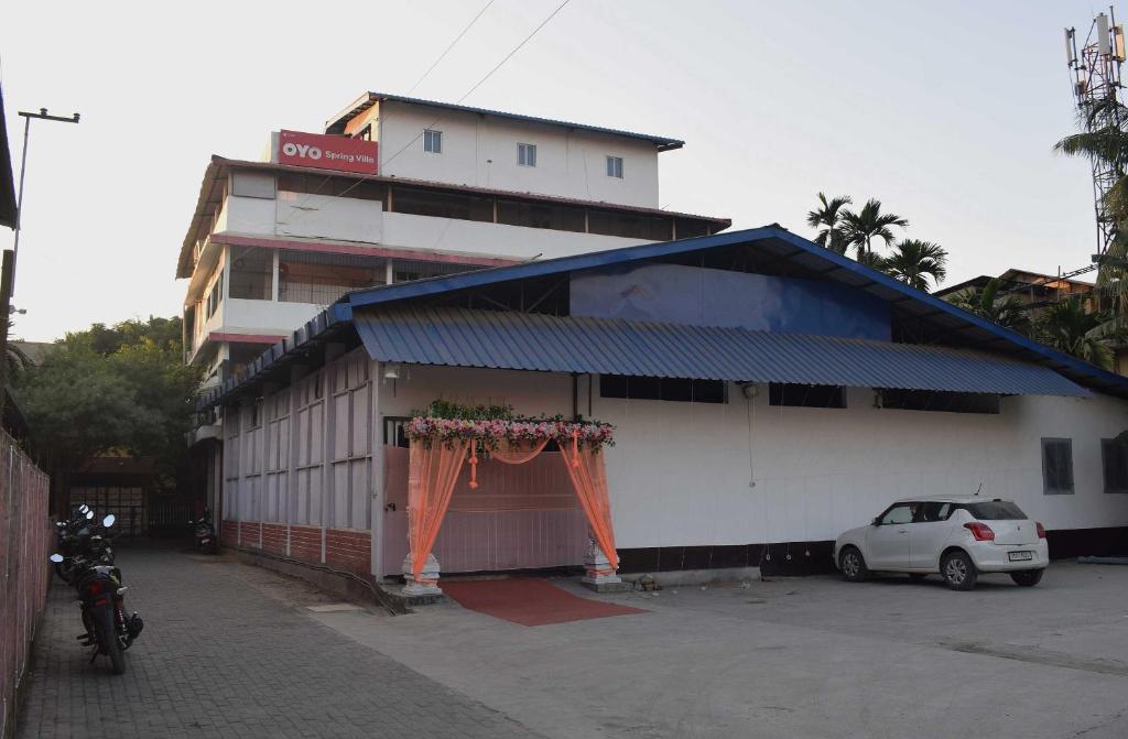 Un coche blanco aparcado delante de un edificio en Hotel O SPRINGVILLA, en Dispur