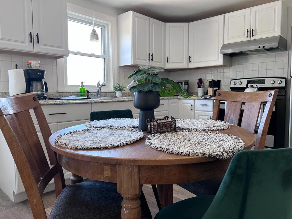 a kitchen with a wooden table with chairs and a tableablish at Mendon Oasis in Woonsocket