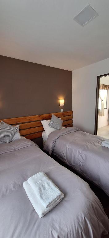 a bedroom with two beds with a white towel on them at Cabañas Paso de Viento in El Chalten