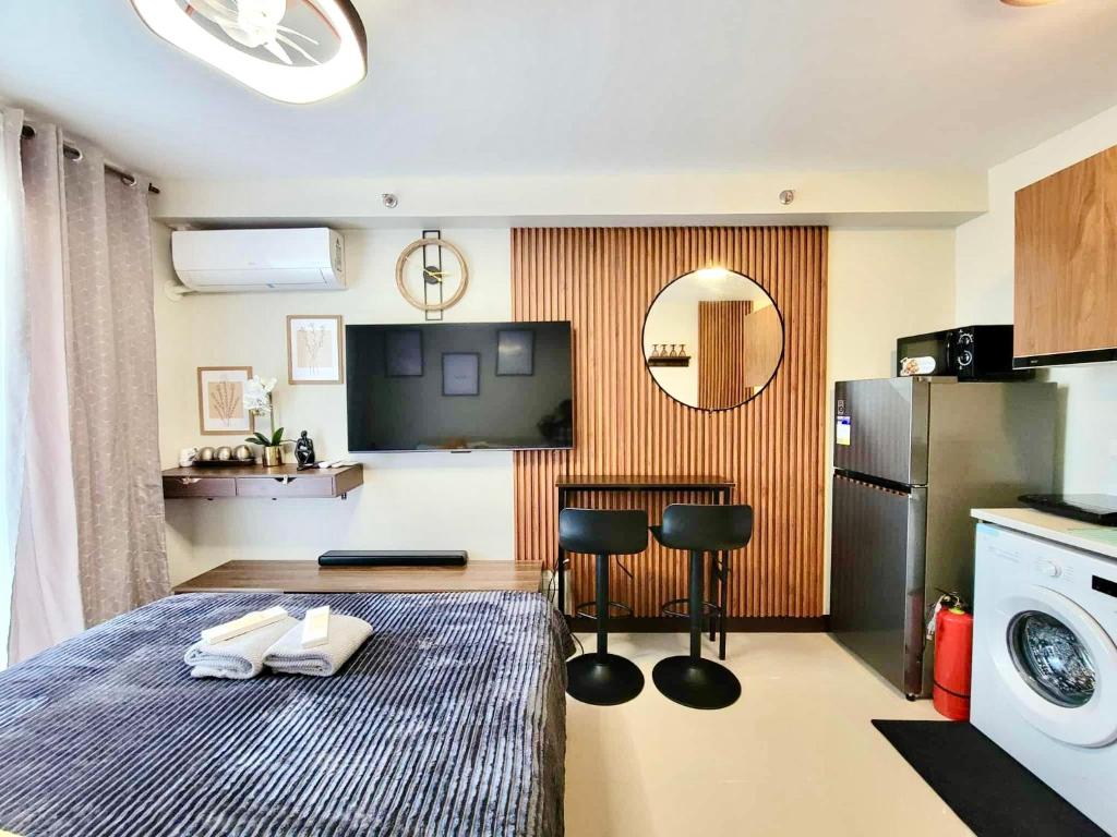 a room with a bed and a kitchen with a washing machine at Welcome to Cozy Staycation in Suba