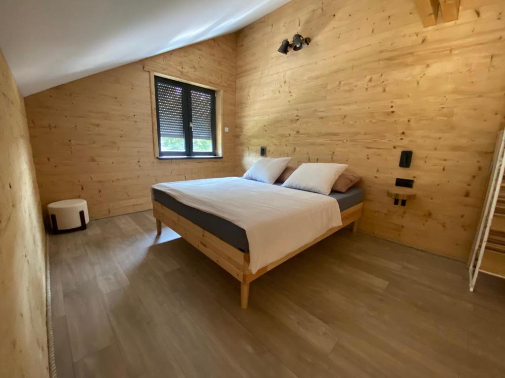 Un dormitorio con una cama en una habitación de madera. en Chalet muguet & spa privatif, en Rochesson