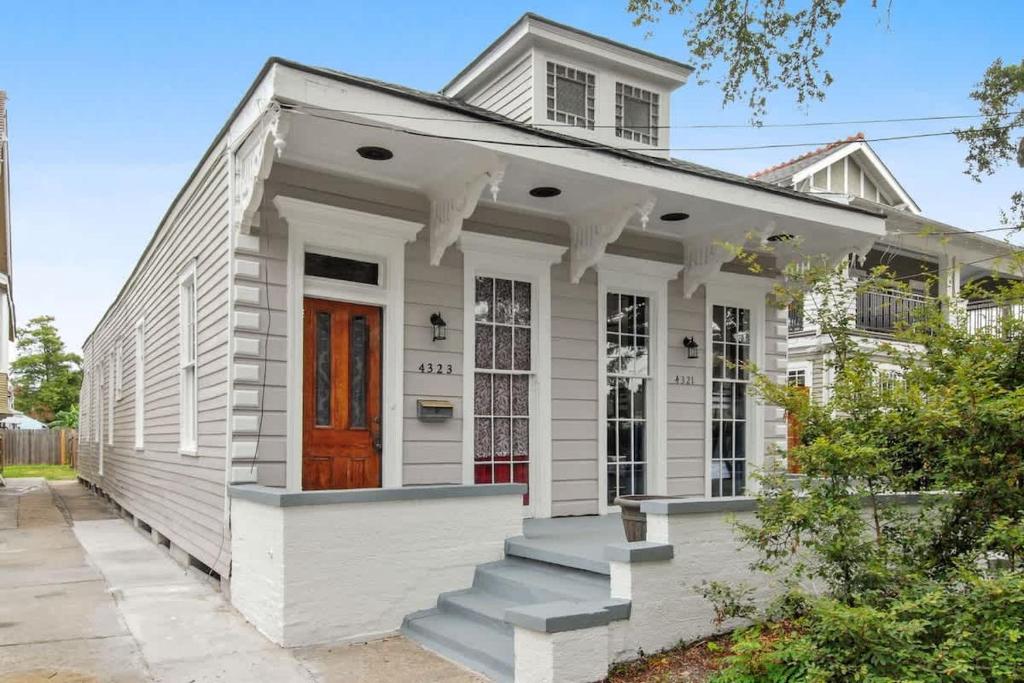 a white house with a red door and stairs at Charming Canal Street Family Retreat in Heart of NOLA in New Orleans