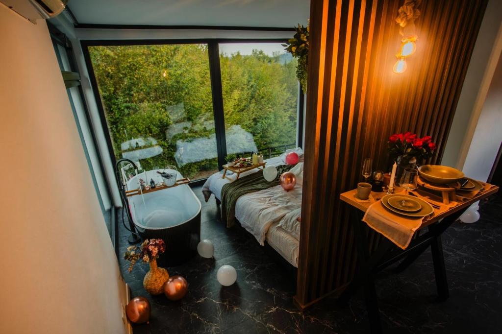 a room with a bed and a table and a window at Tea House Ponoarele in Ponoarele