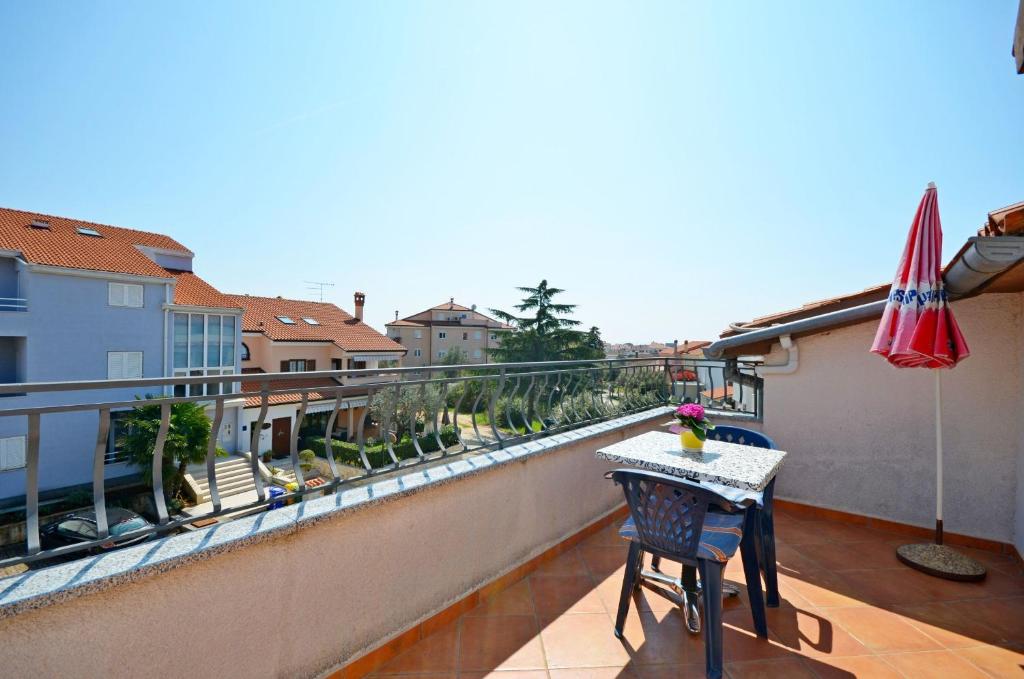 een balkon met een tafel en een parasol bij Apartments Biserka in Štanga
