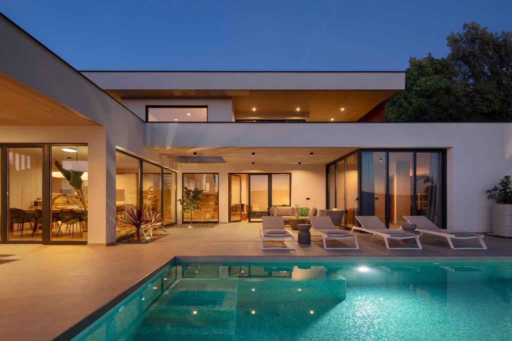 una casa con una piscina di fronte di Villa Immortella a Rabac