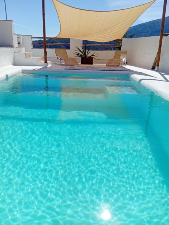 a swimming pool with blue water in a hotel at El nido del dragón in Carratraca