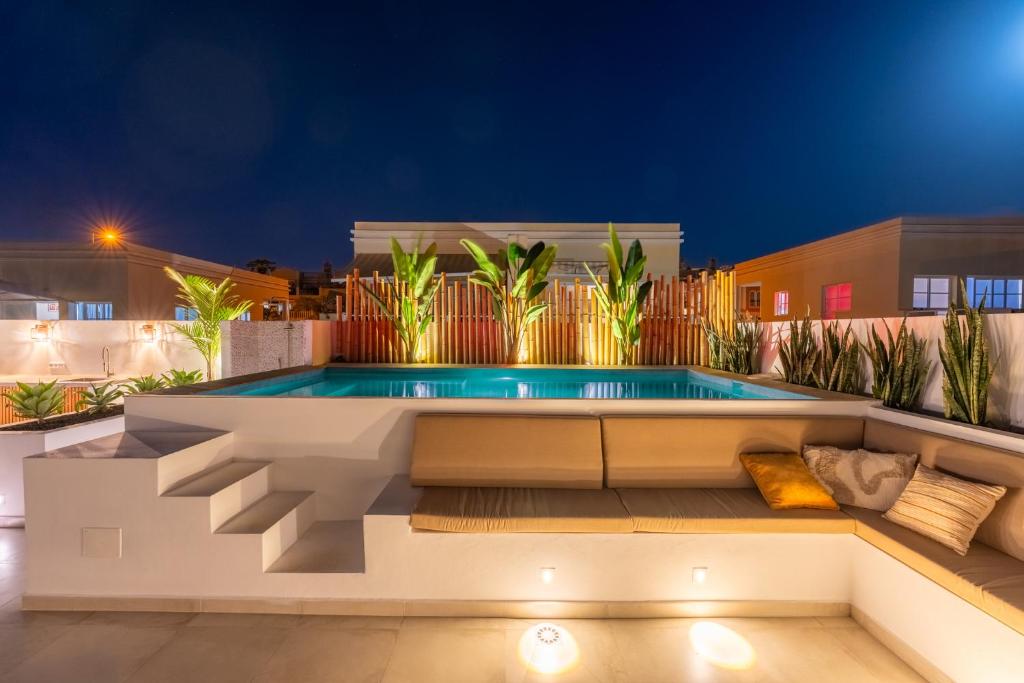 a pool on the roof of a house at night at Luxury Villa - Sunset Rooftop - Heated Pool - Outdoor Kitchen - Airconditioned in Palm-Mar