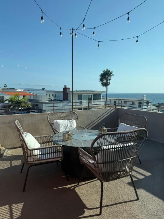 a patio with a table and chairs and the ocean at Ocean View condo in the heart of Manhattan Beach in Manhattan Beach