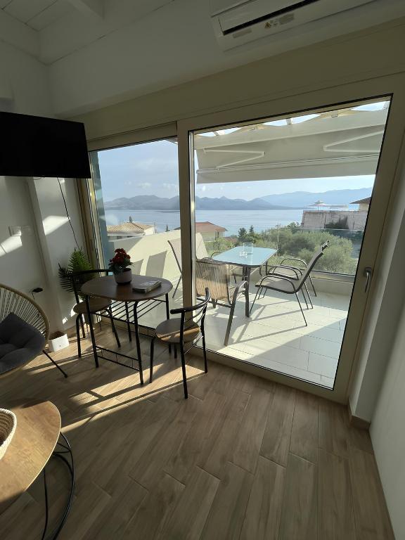 a room with a balcony with a table and chairs at Melodia Lefkada Maisonette 3 in Nikiana