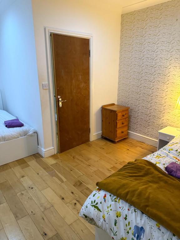 Un dormitorio con una cama y suelo de madera. en Bel Place, en Norwood