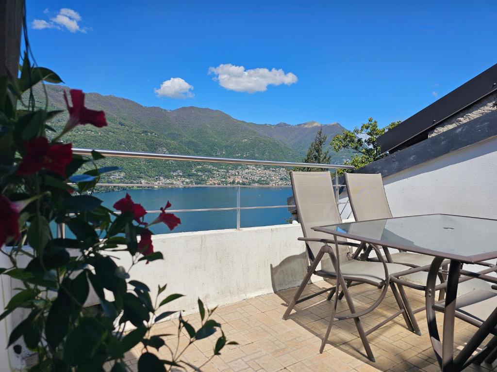 un tavolo e sedie su un balcone con vista di La Terrazza sul Lago di Como con garage a Blevio