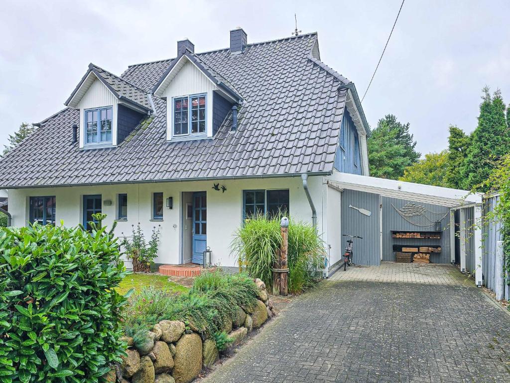 a white house with a garage and a driveway at Ferienhaus "Kleine Auszeit" in Zingst in Zingst