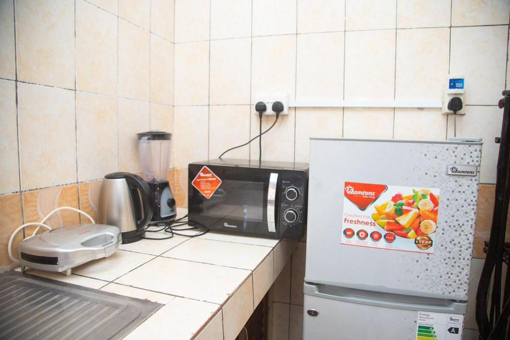 un bancone cucina con forno a microonde e frigorifero. di Ndoto apartment a Ukunda