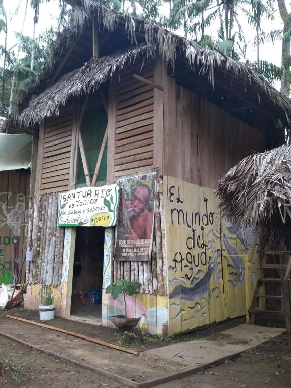 a small house with a sign on the side of it at ECO HOSTAL El VIEJO BOSQUE TOUR AMAZON in Santa Sofía