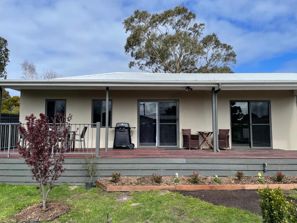 Cette petite maison blanche dispose d'une terrasse couverte et d'un barbecue. dans l'établissement Serenity Cottage Wonthaggi, à North Wonthaggi