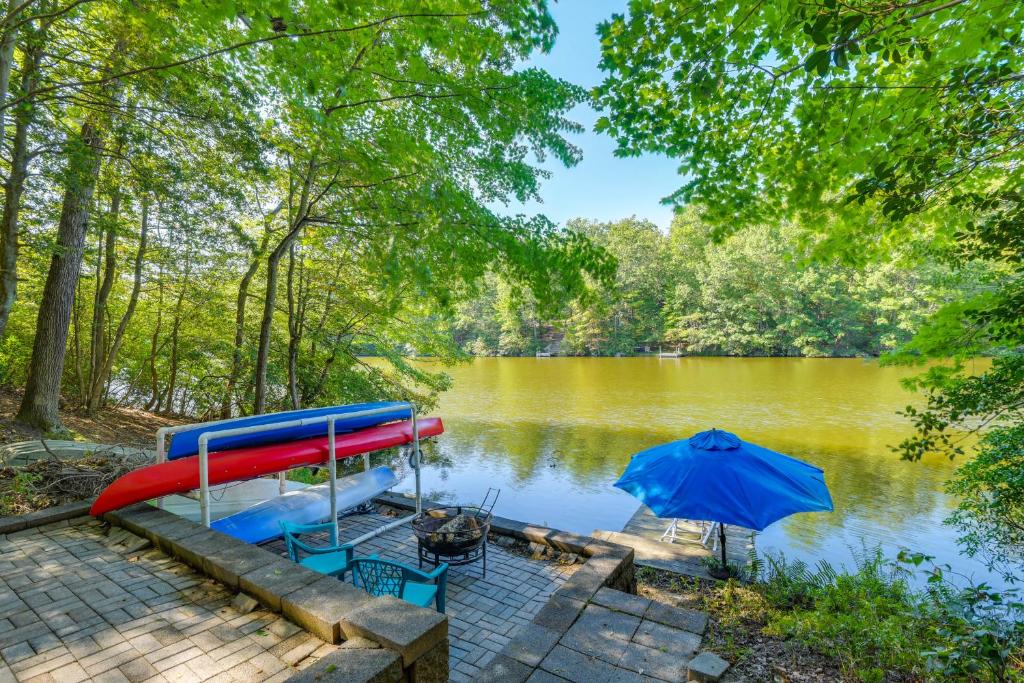 ein Bootshaus mit Rutsche und Sonnenschirm in der Unterkunft Lakefront Log Cabin Retreat 3br-2ba Hot tub and Kayaks in Dowell