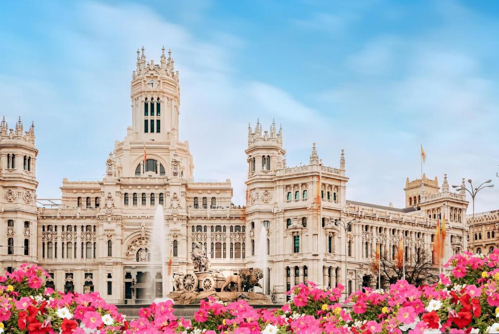 a large building with pink flowers in front of it at Hostel Almansa in Madrid