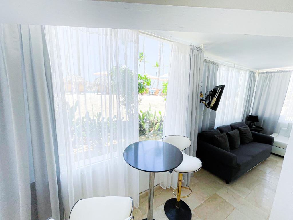 ein Wohnzimmer mit einem schwarzen Sofa und einem Glastisch in der Unterkunft HOMES HOTEL Service in Punta Cana