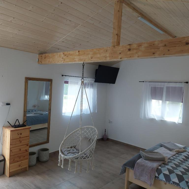 a bedroom with a swinging bed and a mirror at Casuța Casa Dia in Cisnădie