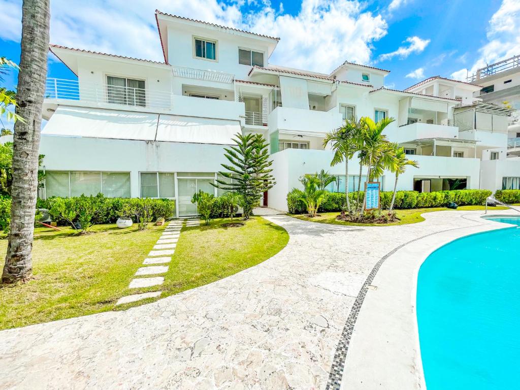 a villa with a swimming pool and a building at Caribbean HOMES HOTEL Service BEACH CLUB & SPA in Punta Cana