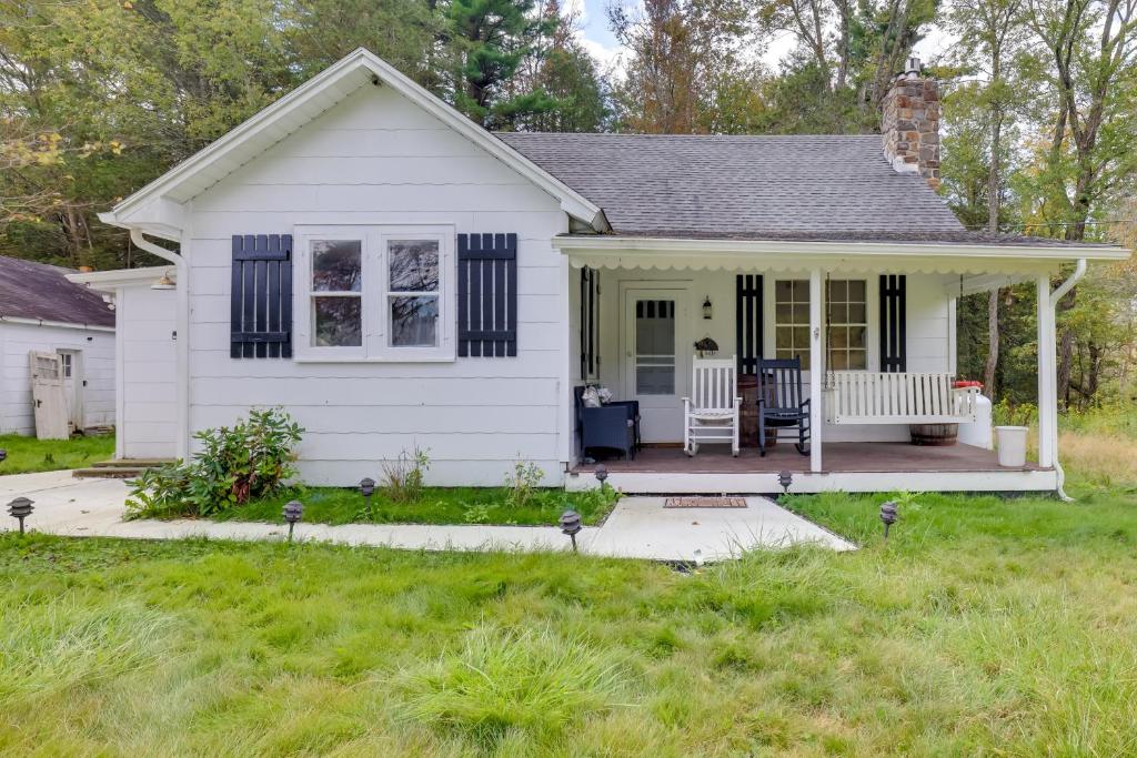 una casa bianca con portico e prato di Private Hot Tub Poconos Babbling Brooke Cottage a Blakeslee