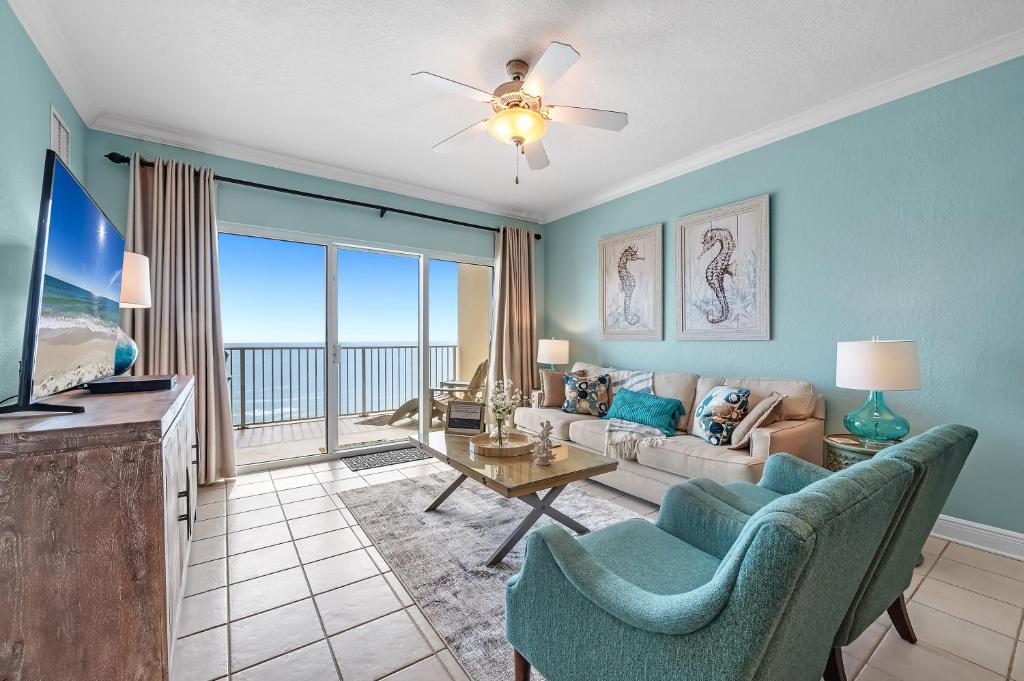 a living room with a couch and a tv at Crystal Shores West Unit 705 in Gulf Shores