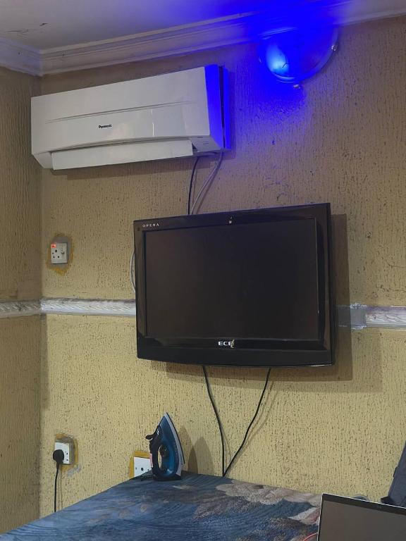 un téléviseur à écran plat accroché au mur dans l'établissement DarcoM, à Ile-Ife