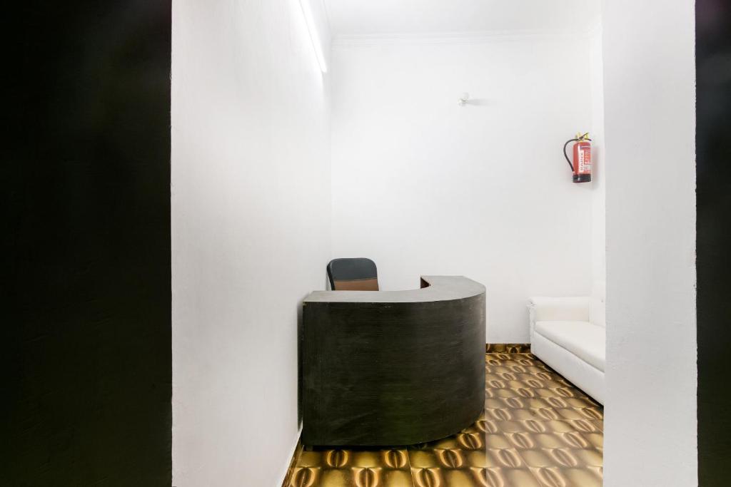 Una silla blanca y negra en una habitación. en Hotel O Kavyanjali, en Ayodhya
