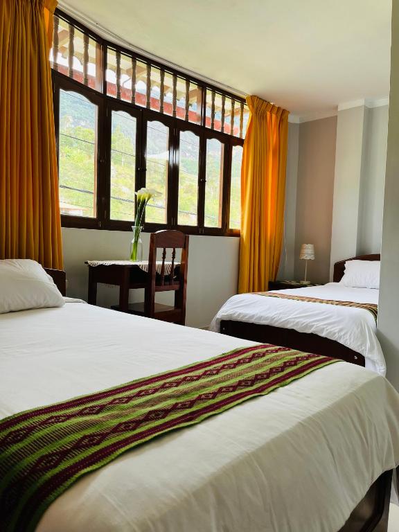 a hotel room with two beds and a window at Hostal Gocta in Cocachimba
