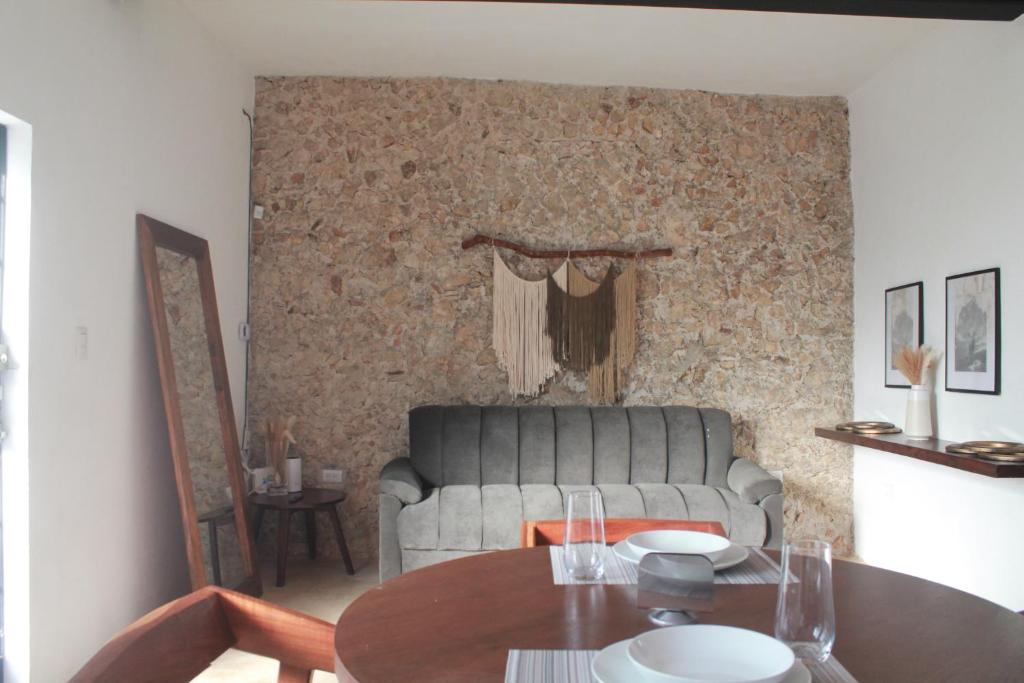 un soggiorno con un divano e un tavolo di Casa Esquina Suite 1 a Mérida