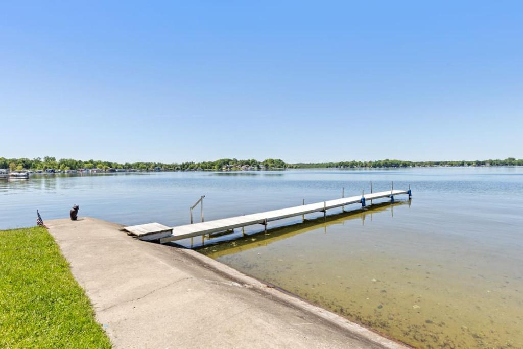 a person sitting at a dock in the water at 7 Cabins & A House on Chippewa Lake in Chippewa Lake