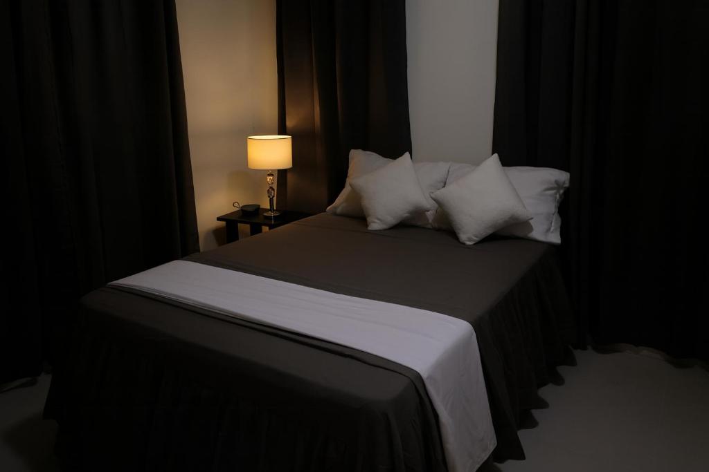 a bedroom with a bed with pillows and a lamp at Modern 3 Bedroom Penthouse Apartment with Free Parking in San Felipe de Puerto Plata