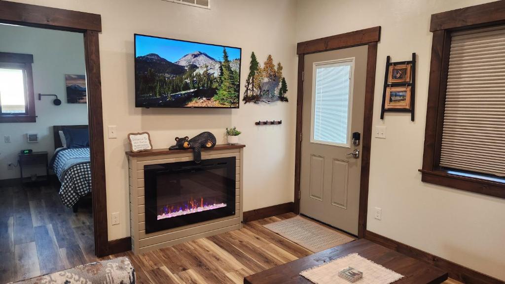 a living room with a fireplace and a tv at Parkside Cabins in West Yellowstone