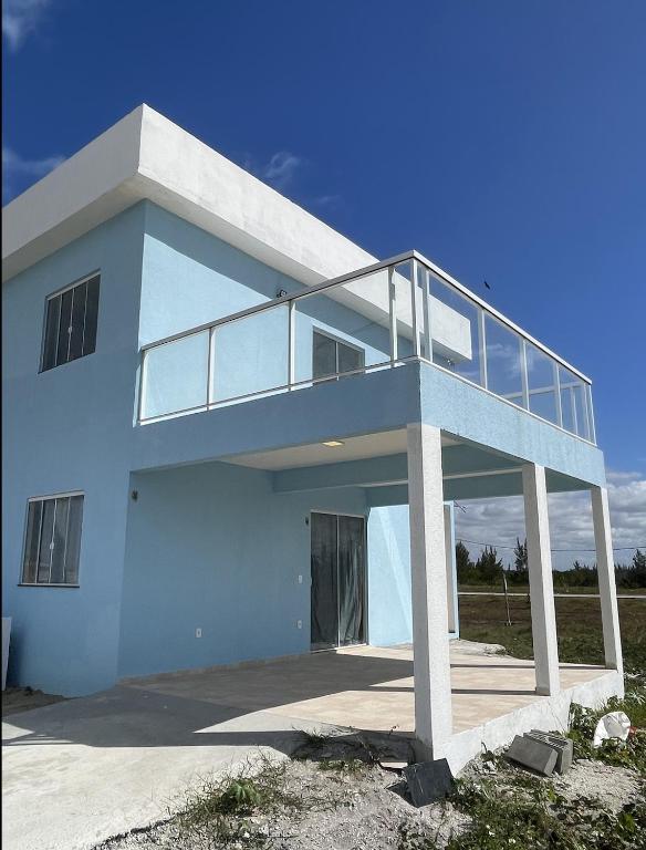 a white house with a balcony on top of it at Ventos de Arubinha in Arraial do Cabo
