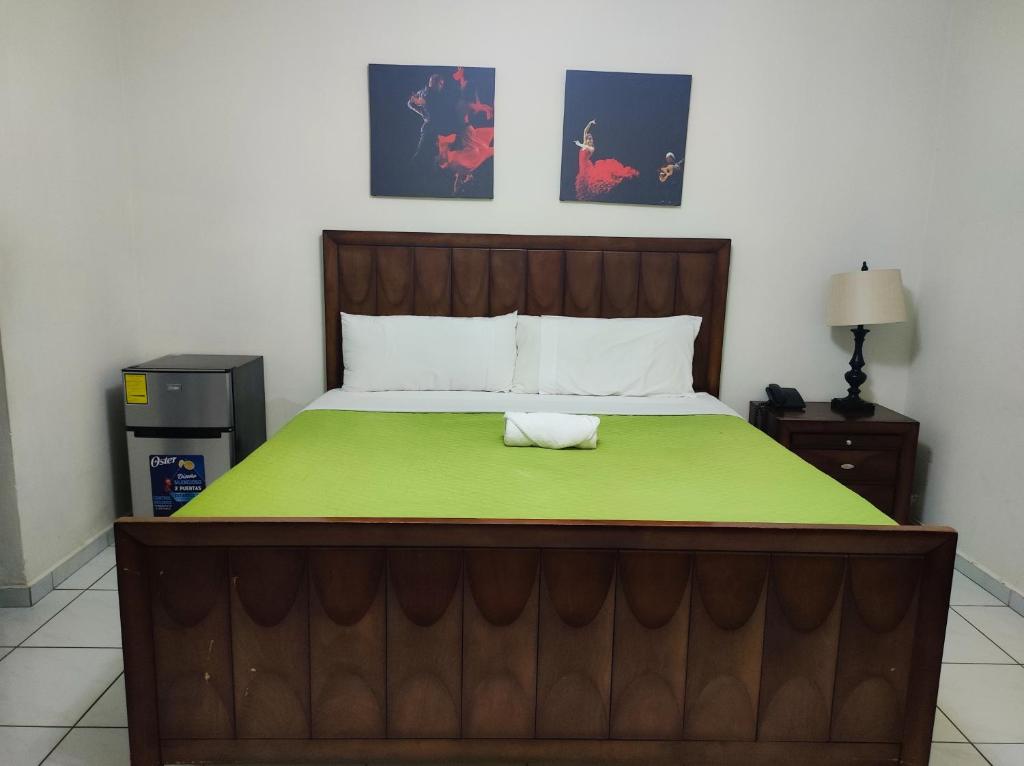 une chambre avec un lit avec une couverture verte dans l'établissement Kartagus Centric, à San Salvador