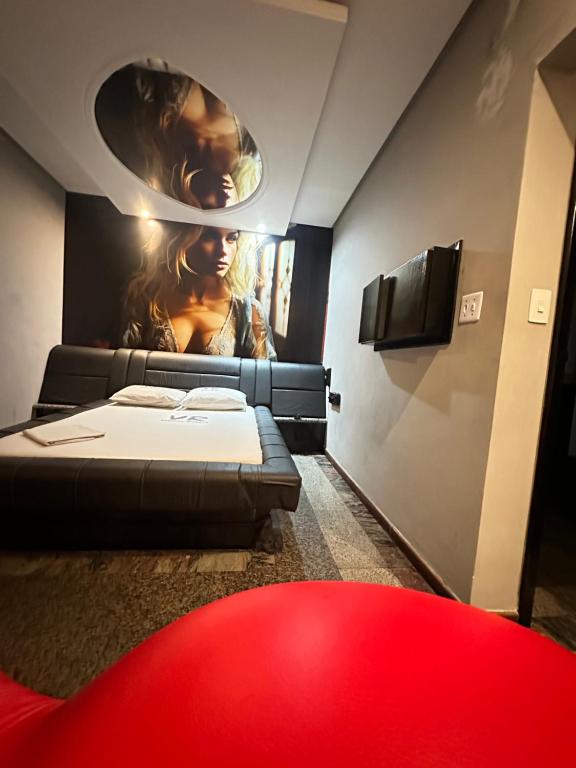a room with two beds and a poster on the wall at Motel Vitoria Reggia in São Vicente
