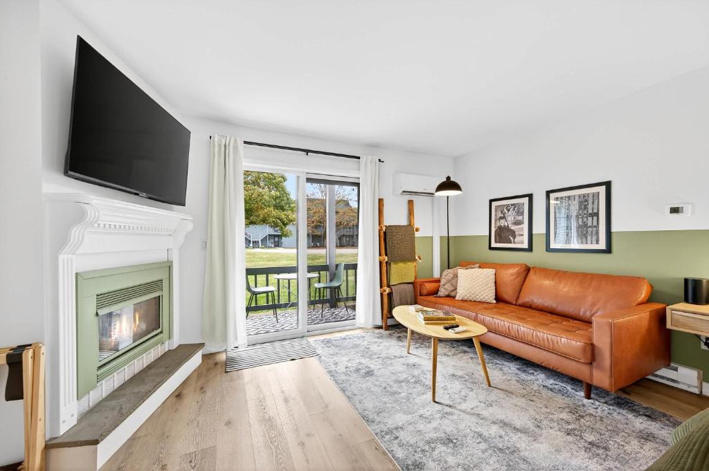 a living room with a couch and a fireplace at King Bed, Walk or Bike to town, EV, Pets OK in Ellicottville