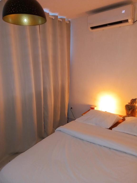 a bedroom with two beds and a lamp and a window at Lagoon Studio Plage in Schœlcher